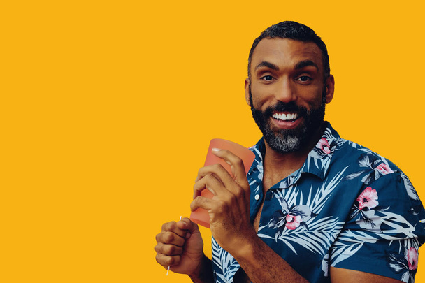 szczęśliwy Afrykanin amerykański człowiek noszenie hawajskiej koszuli z kieliszkiem koktajlowym  - Zdjęcie, obraz
