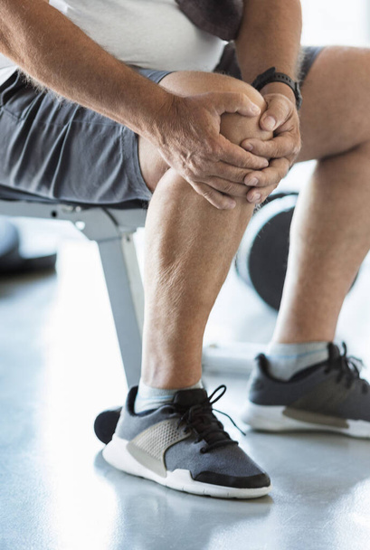 Active senior man in gym with knee injury - Zdjęcie, obraz