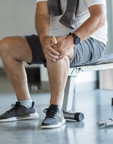 Active senior man in gym with knee injury - Foto, afbeelding
