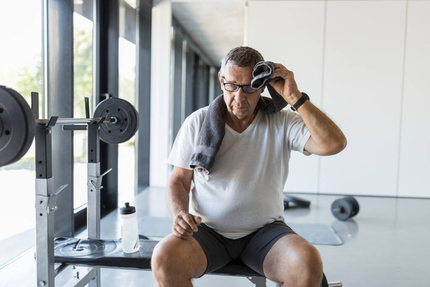 Active and healthy senior exercising in a gym - Фото, изображение