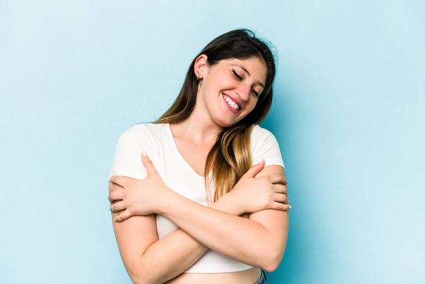 Young caucasian woman isolated on blue background laughing and having fun. - Foto, immagini