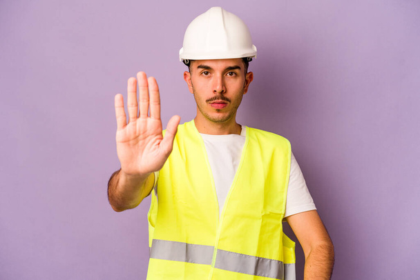 Молодой латиноамериканец, изолированный на фиолетовом фоне, стоял с протянутой рукой, показывая знак "стоп", предотвращая. - Фото, изображение