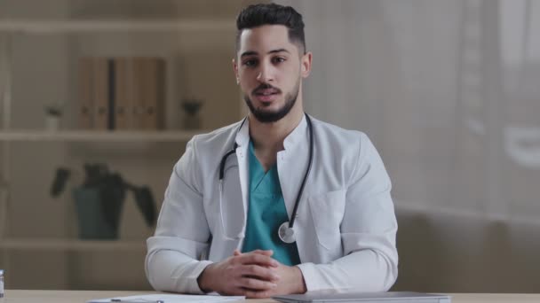 Wykwalifikowany mężczyzna stażysta arabski lekarz lekarz terapeuta psychiatra człowiek facet ostrzec o infekcji wirusem opieki zdrowotnej wstrząsnąć palec wskazujący pokazać nie gest nieporozumienie dać poradę medyczną profesjonalne - Materiał filmowy, wideo