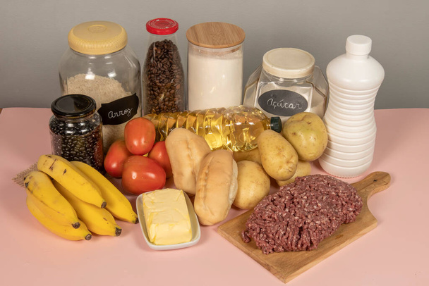 Brazylijski podstawowy koszyk spożywczy składający się z 13 produktów: mięsa, mleka, ryżu, fasoli, chleba, mąki, ziemniaków, pomidorów, chleba, kawy, bananów, cukru, oleju i masła - Zdjęcie, obraz