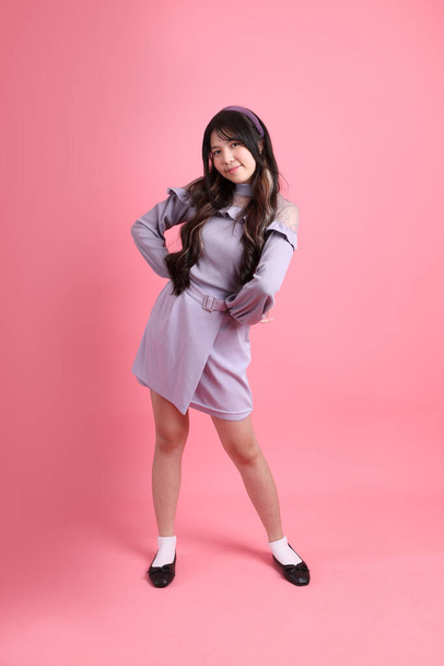 The cute young Asian woman with preppy dressed standing on the pink background. - Φωτογραφία, εικόνα