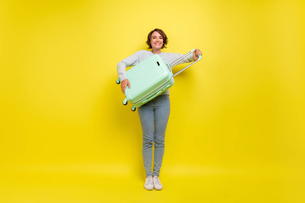 Full length photo of cute young blogger lady with bag wear pullover jeans sneakers isolated on yellow background. - Foto, imagen