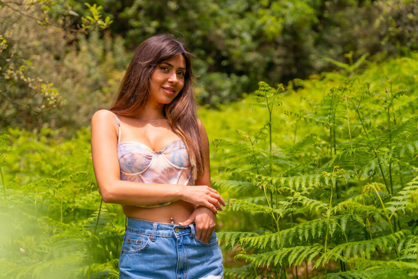 Portrait of a Caucasian girl in ferns on a mountain surrounded by nature, enjoying the fresh air - Foto, imagen