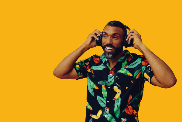 красивий афроамериканський чоловік з навушниками позує на жовтому фоні
 - Фото, зображення