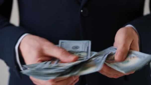 Muodollisesti pukeutunut mies laskee Yhdysvaltain dollarin seteleitä, lähikuva. Investoinnin, menestyksen, taloudellisten näkymien tai uralla etenemisen käsite - Materiaali, video