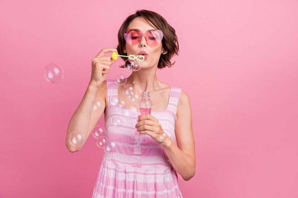 Foto von jungen Mädchen gute Laune blasen Luftblasen verspielt Sonnenbrille Freizeit isoliert über rosa Farbhintergrund. - Foto, Bild