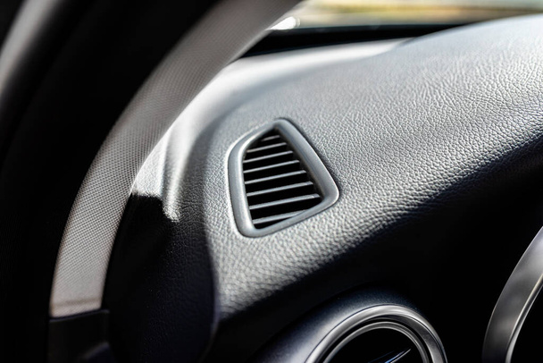 Wnętrze nowoczesnego samochodu osobowego z widocznym prostokątnym przepływem powietrza skierowanym do szyby kierowcy. - Zdjęcie, obraz