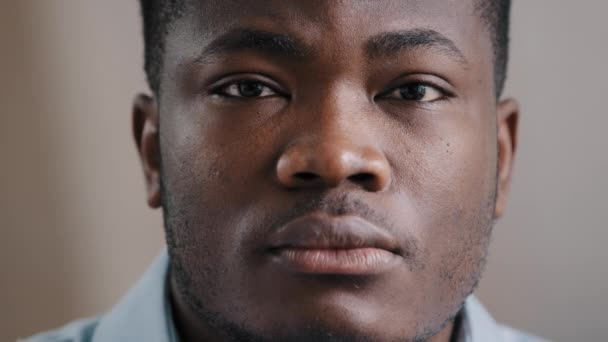 Πορτρέτο ενός σοβαρού όμορφου Αφροαμερικανού νεαρού φοιτητή freelancer που ποζάρει σε εσωτερικούς χώρους Millennial έθνικ λυπημένος μελαχρινός τύπος που κοιτάζει την κάμερα με αυτοπεποίθηση βαθύ βλέμμα δείχνουν έκφραση προσώπου - Πλάνα, βίντεο
