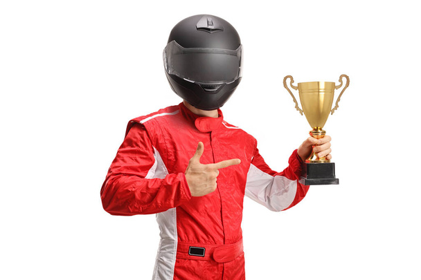 Car racer winner with a black helmet holding a gold trophy cup and pointing at it isolated on white background - Foto, afbeelding