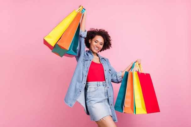 Photo of cheerful shopaholic lady hold retail bags wear jeans jacket mini skirt isolated pink color background. - Fotografie, Obrázek
