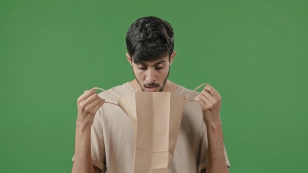 Glücklich männlich Client Käufer arabische Mann Kerl Blick in Paket mit neuen Kauf Geschenk überrascht indischen Verbraucher fühlen Schock auspacken Shopping Lieferung offene Online-Bestellung Waren Artikel stehen über grünen Hintergrund - Filmmaterial, Video