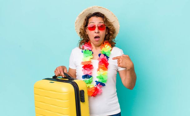 middle age woman looking shocked and surprised with mouth wide open, pointing to self. summer holidays concept - Foto, imagen