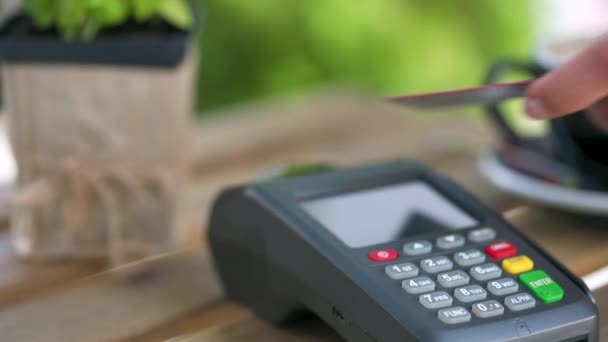 Płatność kartą kredytową NFC. Kobieta płacąca kartą kredytową bez kontaktu z technologią NFC, aby zapłacić zamówienie na terminalu bankowym w kawiarni. Usługi bankowe w zakresie pieniądza elektronicznego. Transakcja pieniądza bezprzewodowego - Materiał filmowy, wideo