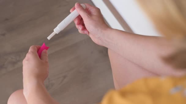 Felismerhetetlen nő terhességi tesztet csinál a fürdőszobában. Pozitív terhességi tesztet tartó lány két vonallal. Közelkép a terhességi teszt készlet a kezében. - Felvétel, videó