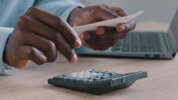 若いアフリカの未知の男銀行家ブックキーパー監査人は、毎月の予算使用計算機を管理支払手形を保持します貯蓄コストを計算チェッククレジット残高割引請求書債務は自宅のオフィスに座る - 映像、動画