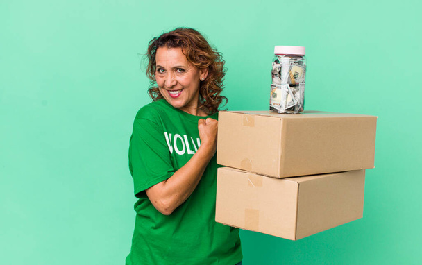 middle age woman feeling happy and facing a challenge or celebrating. volunteer and donation concept - 写真・画像
