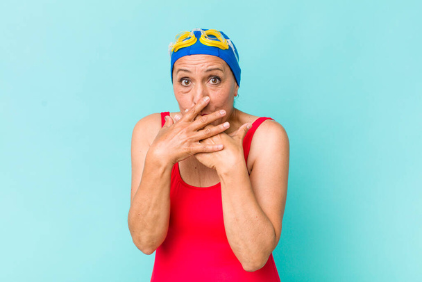 middle age woman covering mouth with hands with a shocked. swimming concept - Zdjęcie, obraz