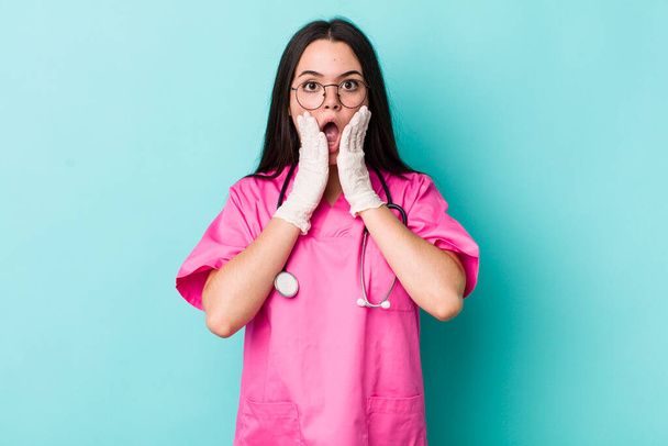 young adult woman feeling shocked and scared. veterinarian concept - Foto, Bild