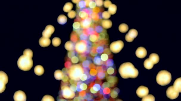 Large New Years Christmas tree decorated with luminous multi-colored garlands and illumination at night. Christmas tree with flashing lights. Blurred background. New Year and Christmas holidays - Footage, Video
