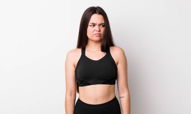 young adult woman feeling sad, upset or angry and looking to the side. fitness concept - Photo, image