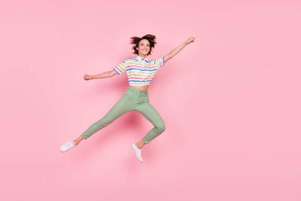 Full body photo of young girl happy positive smile fly air superwoman catch parasol jump isolated over pink color background. - Valokuva, kuva