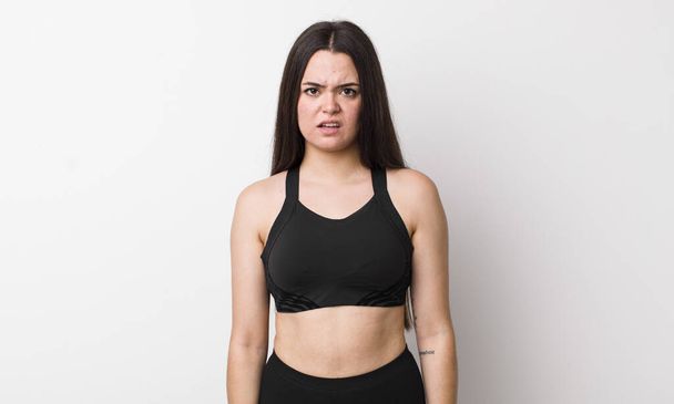 young adult woman feeling puzzled and confused. fitness concept - Фото, зображення