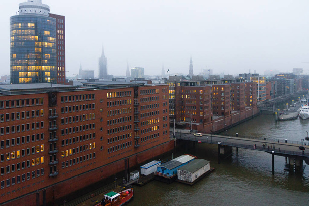 Hamburg mglisty panorama i kanał widok Speicherstadt dzielnicy magazynowej z Elbphilharmony sali koncertowej. - Zdjęcie, obraz
