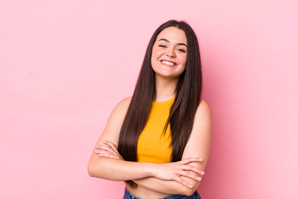 young adult woman laughing happily with arms crossed, with a relaxed, positive and satisfied pose - Photo, Image