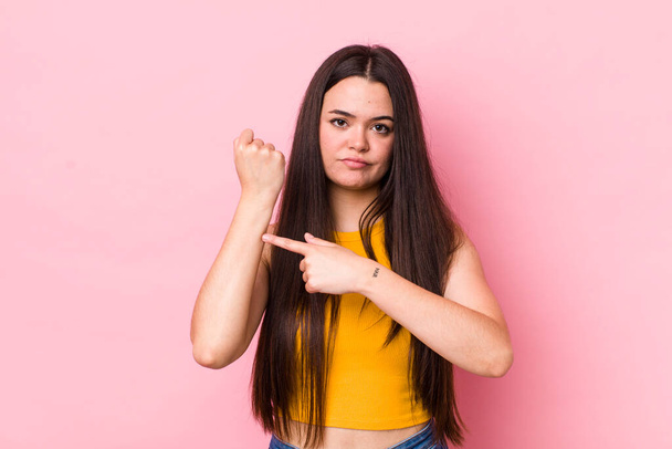 young adult woman looking impatient and angry, pointing at watch, asking for punctuality, wants to be on time - Photo, image