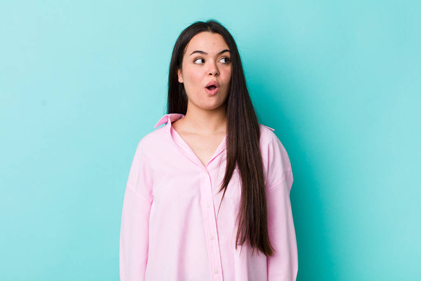 young adult woman feeling shocked, happy, amazed and surprised, looking to the side with open mouth - Foto, Bild