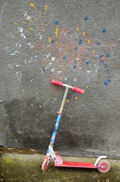 használt gyermek kick robogó fal közelében - Fotó, kép