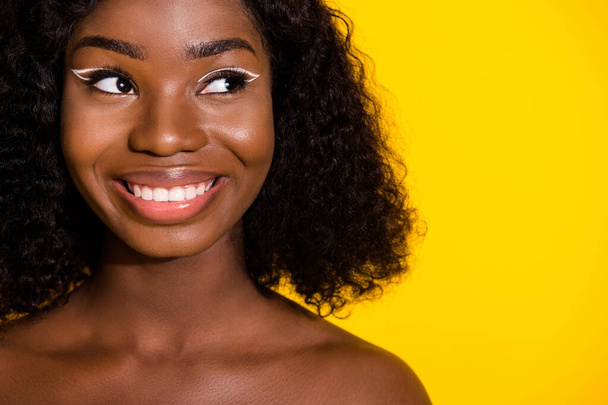 Фото молодої веселої милої африканської жінки, одягненої без одягу, виглядають копії простору, що мріє ізольовано на жовтому тлі
. - Фото, зображення
