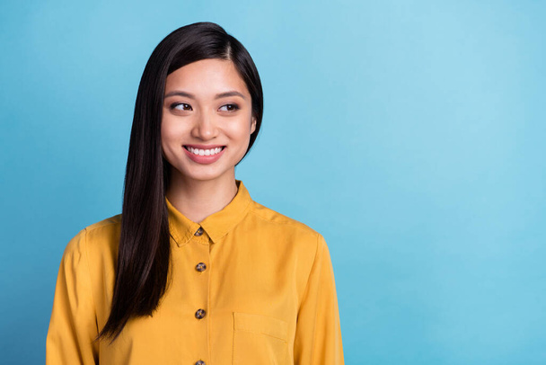 Photo of young attractive asian girl happy positive smile curious dream think look empty space isolated over blue color background. - Foto, Imagem