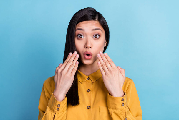 Photo of young asian girl amazed shocked surprised fake novelty news isolated over blue color background. - Foto, Imagen