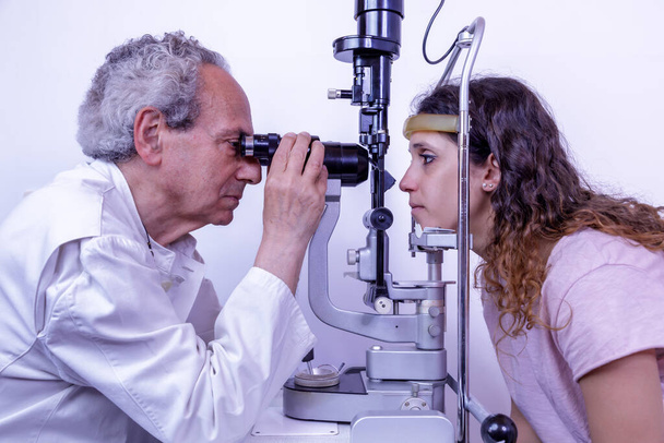 Eye doctor visita il paziente utilizzando uno strumento speciale. La pachimetria è un test diagnostico che consente di misurare lo spessore della cornea. - Foto, immagini