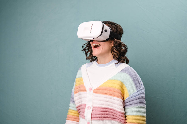 Frau genießt Virtual Reality mit VR-Headset über einem isolierten Hintergrund. Technologie und Innovationskonzept. - Foto, Bild