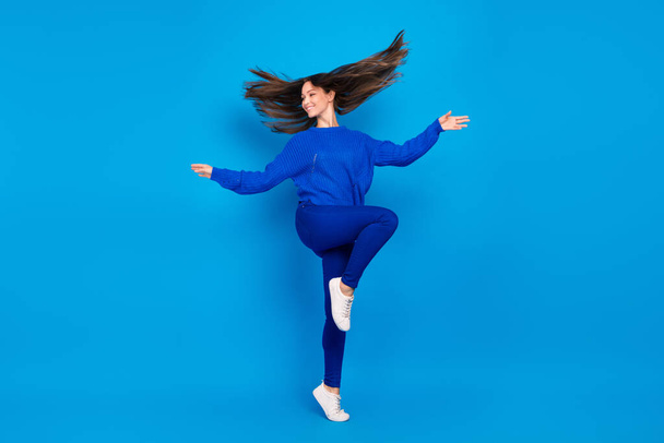 Lunghezza completa dimensione del corpo vista di attraente ragazza allegra divertirsi saltando gettando i capelli isolati su vivido sfondo di colore blu. - Foto, immagini