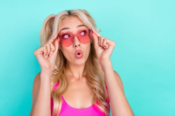 Portrait of attractive amazed curious wavy-haired girl touching specs pout lips isolated over bright teal turquoise color background. - Foto, imagen