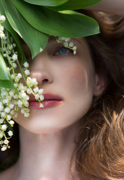Portrait of happy young beautiful woman with lily of the valley bouquet. Top view. - Photo, Image