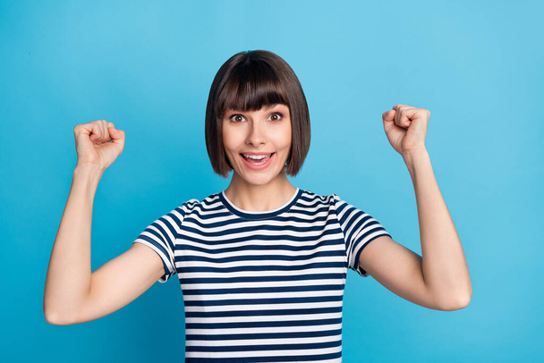 Photo of charming happy positive woman raise hands fists winner smile cool isolated on blue color background. - Φωτογραφία, εικόνα
