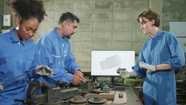 Trois équipes multiraciales d'ingénieurs de l'industrie dans des emplois d'uniformes de sécurité en métallurgie discutent avec un dessin mécanique dans un moniteur, des machines de tour et un atelier dans une usine de fabrication. - Séquence, vidéo
