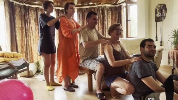 I membri della famiglia si fanno a turno facendo un massaggio alle spalle nel soggiorno della casa. - Filmati, video