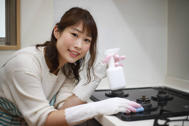 Eine Frau putzt einen Gasherd - Foto, Bild