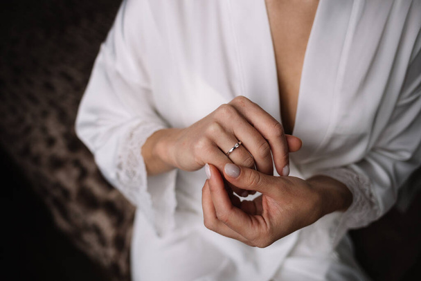 2つの金の結婚指輪。花嫁は新郎新婦の結婚指輪をしています。指に指輪をつけて新婚旅行。結婚式の屋外。二人は結婚指輪を交換する。結婚したばかり - 写真・画像
