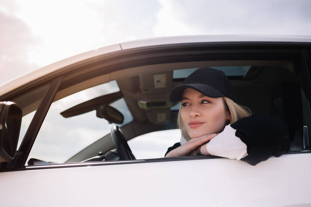 Młoda piękna kobieta uśmiechający się jazdy samochodem. Jej córka siedzi na tylnej i cieszyć. - Zdjęcie, obraz
