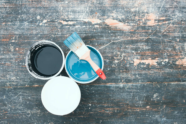 House renovation concept.Paint cans and brush on the old wooden background with copy space - Foto, Imagem